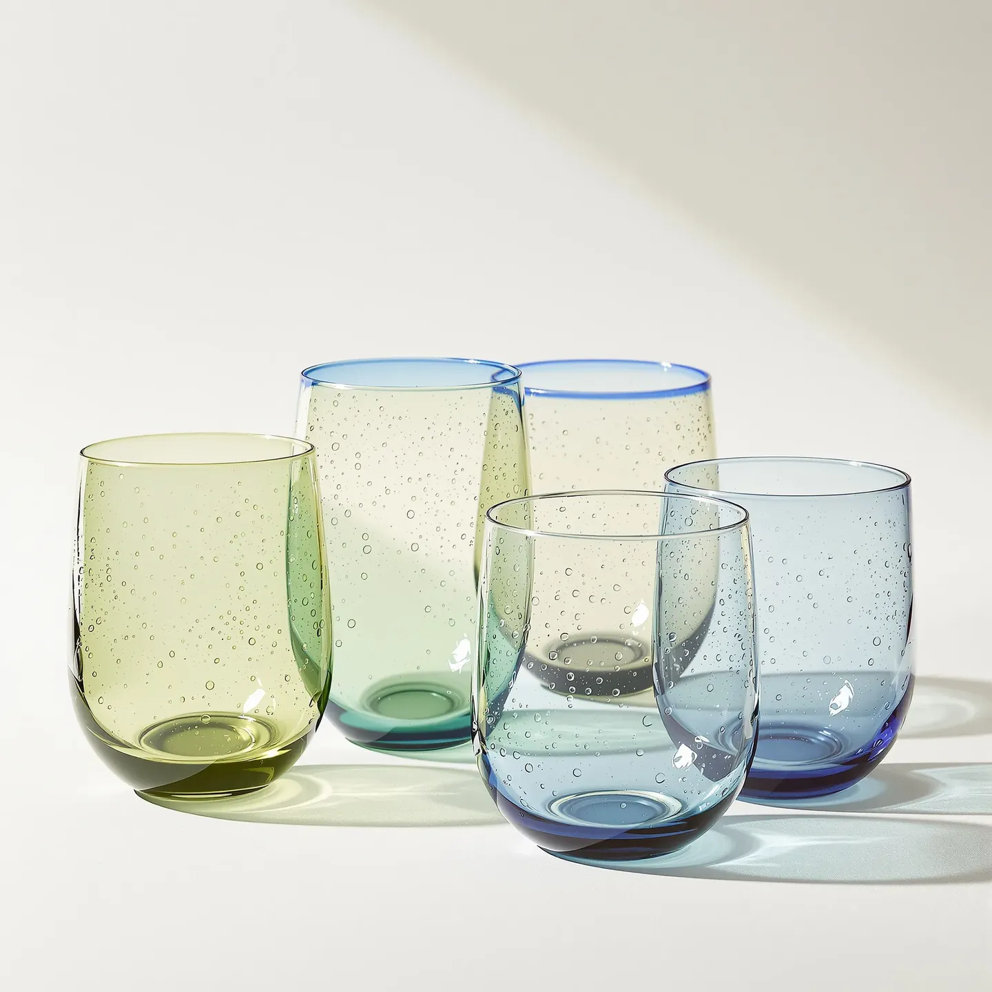 Four hand-blown recycled glass tumblers with a faint green tint
