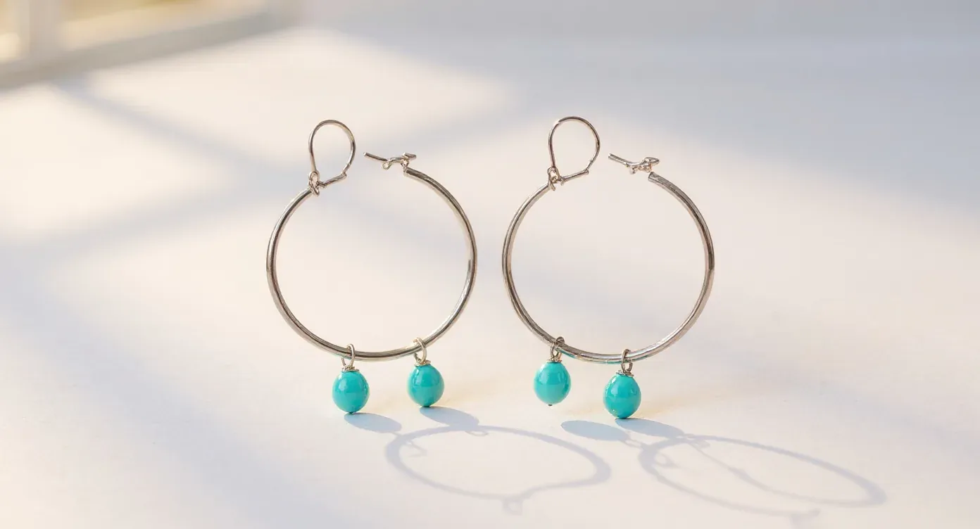 The same silver and turquoise hoop earrings as a clean catalog packshot on an off-white background