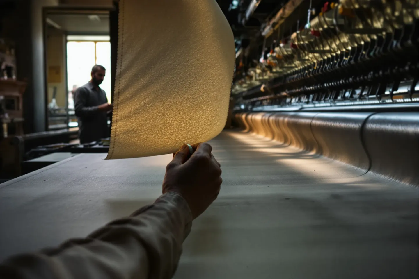A fabric roll running over a backlit inspection frame in a weaving mill